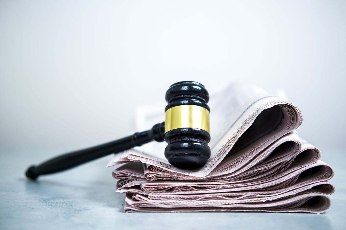 Stack of legal newspapers beside a judge's gavel