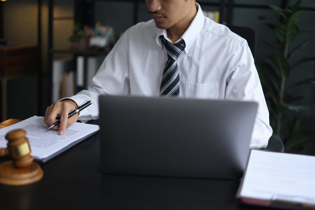 Attorney reviewing legal paperwork on a laptop